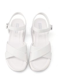 Sandali platform bianchi con cinghie incrociate, realizzati in materiale sintetico, dotati di fibbia regolabile alla caviglia e dalla texture liscia.