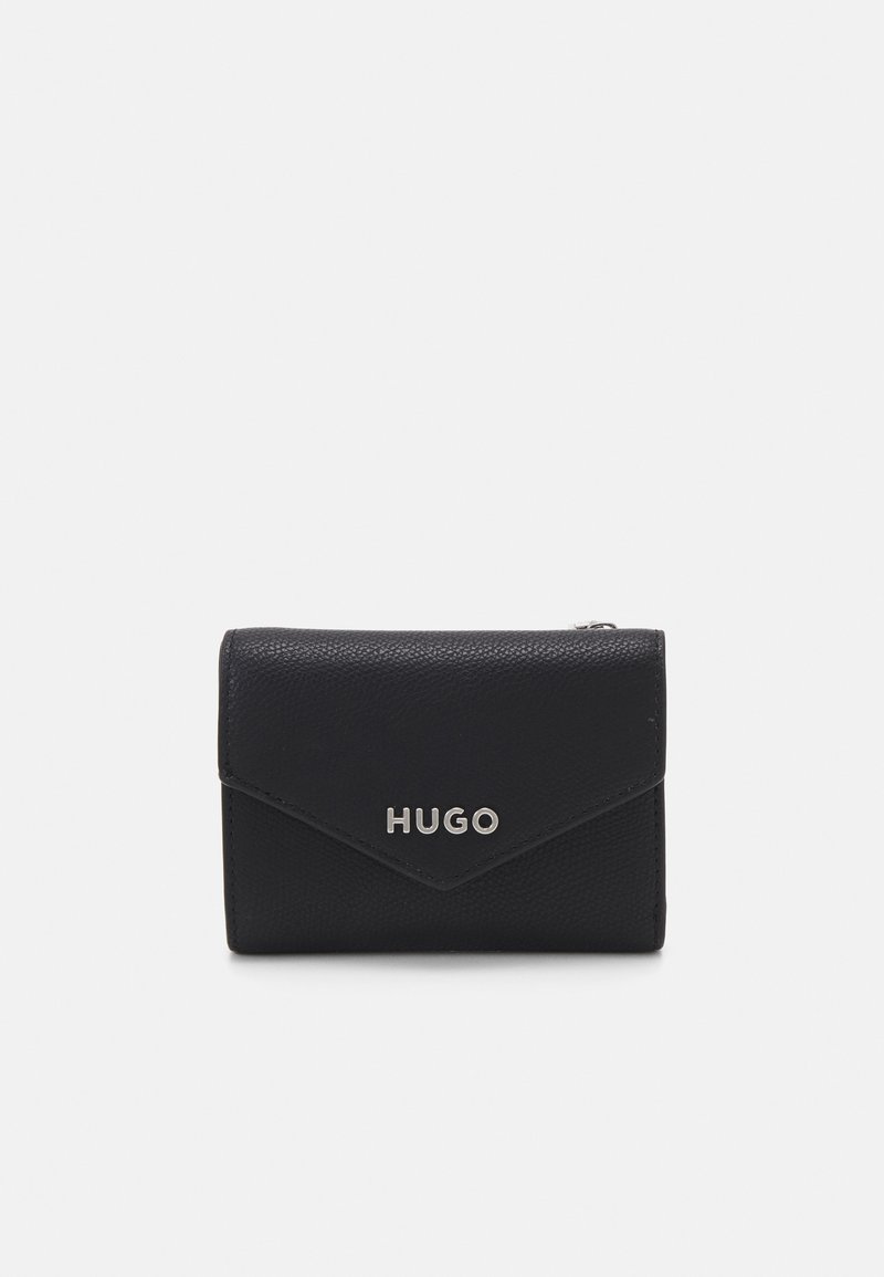 Portafoglio in pelle nera con texture a grana, caratterizzato da un design a pattina e logo "HUGO" argento sulla parte anteriore. Forma compatta e rettangolare.