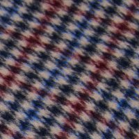 Tkanina s tkaným vzorom houndstooth v červenej, modrej a krémovej farbe, s jemným textúrovaným povrchom a subtílnym leskom.