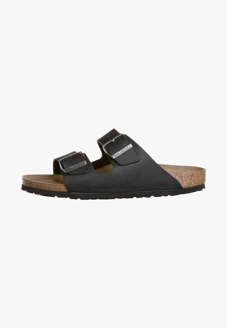 Black sandals with two adjustable buckles, a cork footbed, and a textured rubber sole. Simple design, flat profile, and casual style.