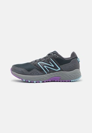 Zapatillas deportivas con una parte superior de malla gris oscuro, acentos en azul claro y una suela exterior texturizada en gris con detalles morados. Diseño transpirable y liviano.