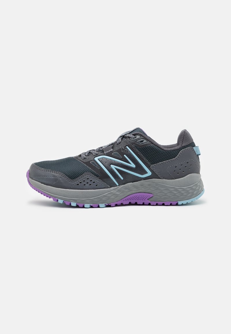 Zapatillas deportivas con una parte superior de malla gris oscuro, acentos en azul claro y una suela exterior texturizada en gris con detalles morados. Diseño transpirable y liviano.
