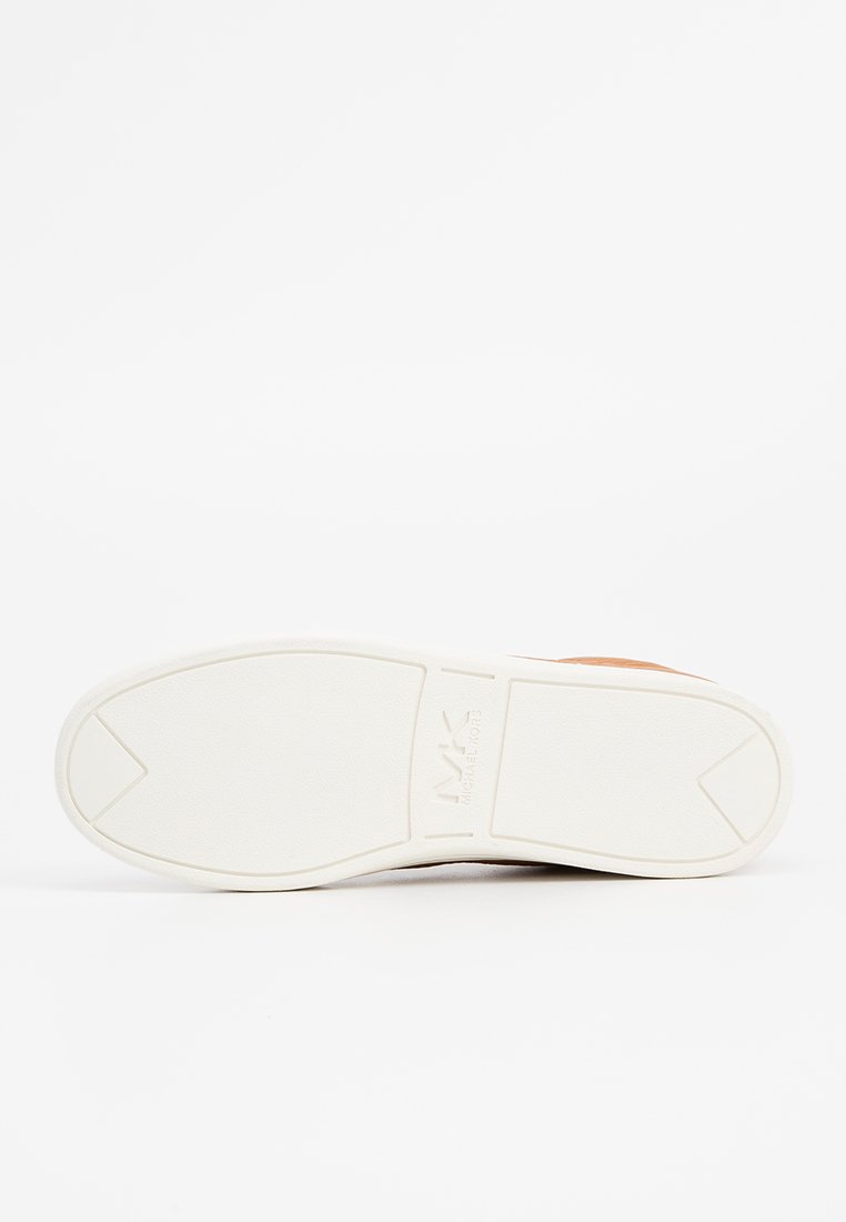 Semelle de sneaker blanche avec un motif texturé, présentant un logo en relief et une forme contournée. Contraste de couleur entre la semelle et la section supérieure visible.