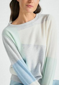 Lichtgewicht gebreid sweater met een pastel kleurblokpatroon in mint, blauw en grijs. Kenmerkt een brede halslijn en lange mouwen.