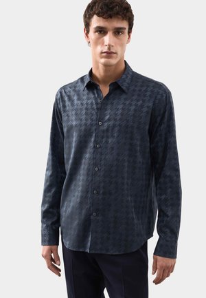 Donkerblauwe longsleeve shirt met een subtiele houndstooth patroon, met een button-down kraag en knopen aan de voorkant. Glad materiaal met een relaxte pasvorm.