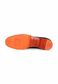 Svart skosula med ett orange inlägg. Har en strukturerad yta och präglad logodetalj. Rundad tå och platt profil.