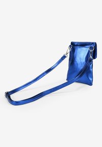 Bolso cruzado metálico azul con forma rectangular, que presenta un diseño plano, correa ajustable y acabado brillante. Sin detalles de hardware visibles.
