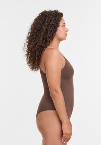 Costume da bagno intero marrone con spalline sottili, texture liscia e design aderente, che mostra una vista laterale della silhouette del capo.
