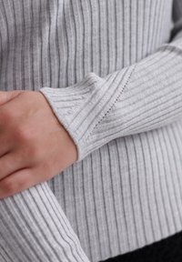 Szary sweter w prążki, prezentujący teksturowany splot z kontrastującymi poziomymi paskami, z dopasowanymi mankietami i miękkim, ciepłym wyglądem.