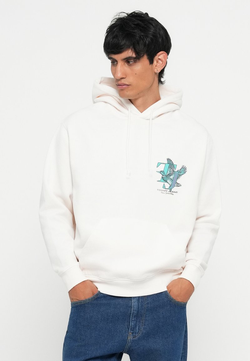 Weißer Kapuzenpullover mit einer vorderen Kängurutasche, der ein türkisfarbenes grafisches Design auf der Brust mit einem Vogel und Logo-Text zeigt.