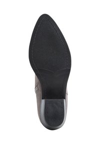 Zapato de ante gris con punta afilada, que presenta una suela de goma negra texturizada y un sutil detalle de costura a lo largo de los lados.