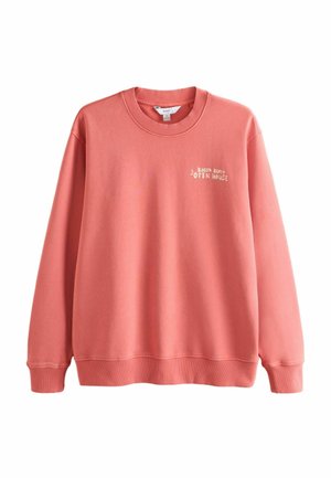 Coral pink crewneck sweatshirt with ribbed cuffs and hem, featuring small white text "Bossa Beach Open House" on the left chest.