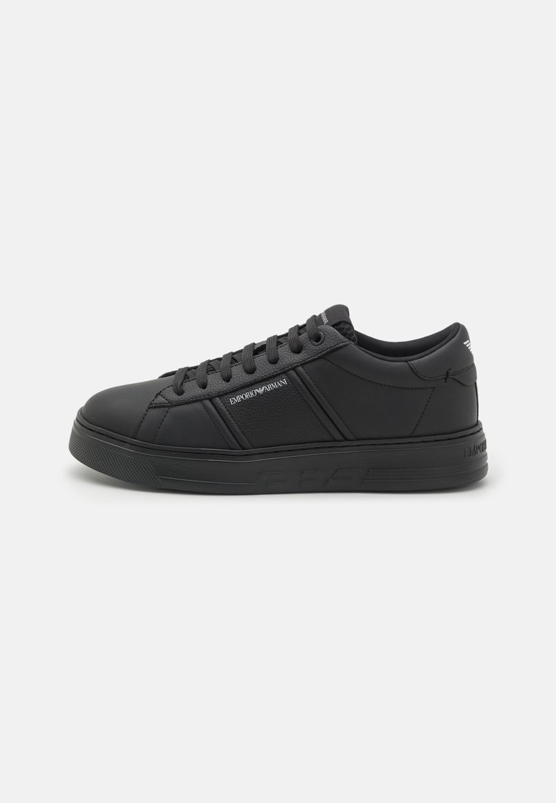 Baskets basses noires avec lacets à l’avant, semelle texturée et logo "Emporio Armani" sur le côté et la languette du talon.