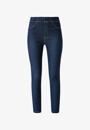 Ciemnoniebieskie skinny jeans z kontrastującymi szwami, połączone z burgundowym swetrem o fakturze i białymi, granatowymi oraz czerwonymi sportowymi sneakersami.