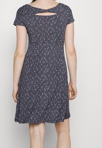 Sukienka z krótkim rękawem w ciemnoszarym kolorze z kwiatowym wzorem w odcieniach niebieskiego i różowego. Posiada wycięcie na plecach z małym detalem w postaci kokardki oraz rozkloszowany dół.