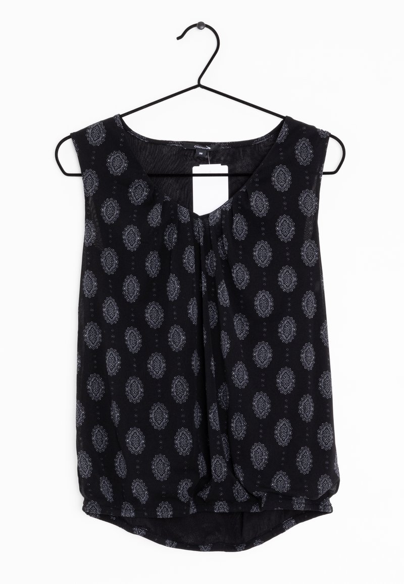 Blouse noire sans manches avec motifs paisley ovales gris, col rond, léger plissé à l'avant et ourlet asymétrique, sur un cintre noir.