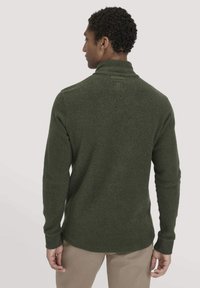 Dunkelgrüner Strickpullover mit hohem Kragen, langen Ärmeln und strukturiertem Finish. Verfügt über ein dezentes Logo auf der Rückseite und nahtdetails.