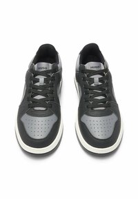 Czarno-szare sneakersy z perforowanym noskiem, płaskimi sznurowadłami, wyściółką na kołnierzu, gumową podeszwą i logo na języku, z gładkim i teksturowanym wykończeniem.