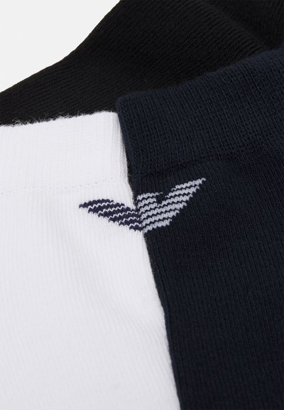Calcetines de algodón en negro, blanco y marino, con una textura acanalada y un logotipo bordado en blanco y gris en la sección marina.