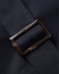 Tamsiai mėlynas audinys su įstrižine tekstūra, su stačiakampiu rudu metaliniu segtuku, ant kurio išgraviruota "TOMMY HILFIGER." Tvirtai siuvinėta, elegantiškas dizainas.