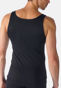 Black tank top made of smooth, stretchy fabric, featuring a round neckline and sleeveless design, with a fitted silhouette and no additional details.