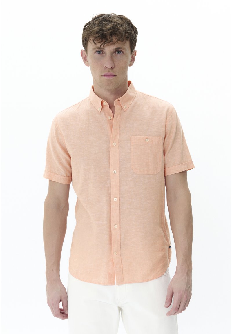 Camicia a maniche corte con bottoni in tessuto pesco chiaro, caratterizzata da una tasca sul lato sinistro del petto e piccoli bottoni bianchi.