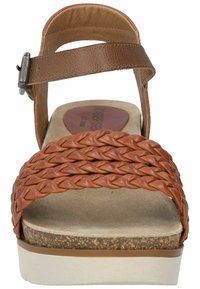 Sandal in pelle intrecciata marrone con una fascia larga, cinturino alla caviglia regolabile e una suola in sughero con un accento beige.