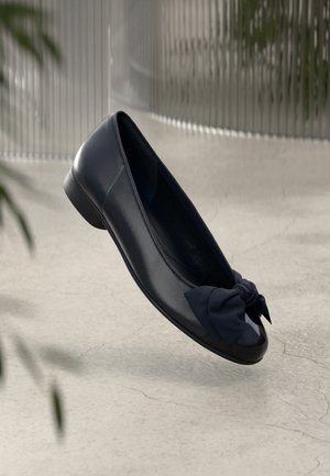 Granatowe skórzane baleriny z okrągłym noskiem i dekoracyjną, zawiązaną kokardą. Gładkie wykończenie, niski obcas i elastyczne krawędzie dla wygody.