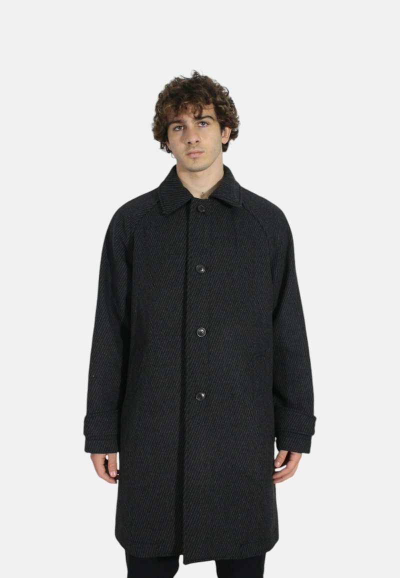 Cappotto nero a spina di pesce con colletto, cinque bottoni e maniche lunghe, caratterizzato da una vestibilità rilassata e un tessuto a trama.