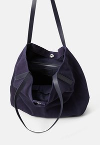 Navy suede tote bag with a wide opening, single interior compartment, two straps, and a snap closure. Smooth texture and structured shape.