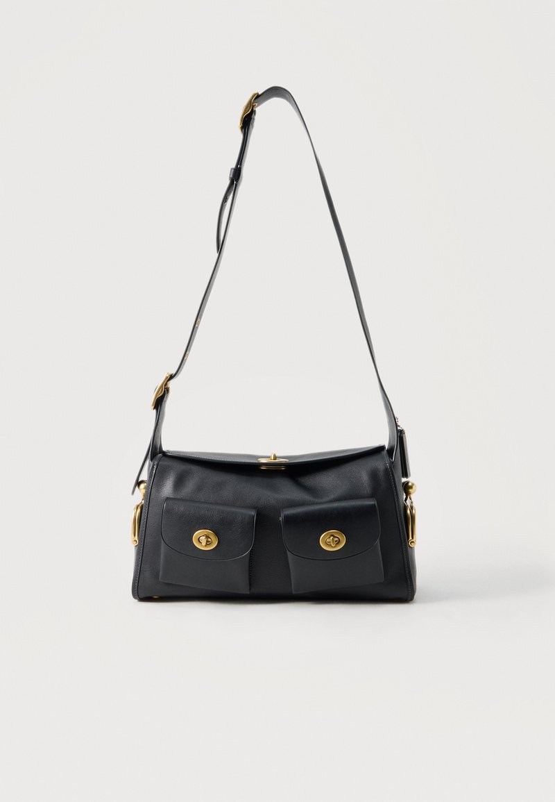 Μαύρη δερμάτινη τσάντα ώμου με δύο μπροστινές θήκες και κλεισίματα με χρυσούς περιστροφικούς μηχανισμούς, ρυθμιζόμενο λουρί και μινιμαλιστικό σχεδιασμό.