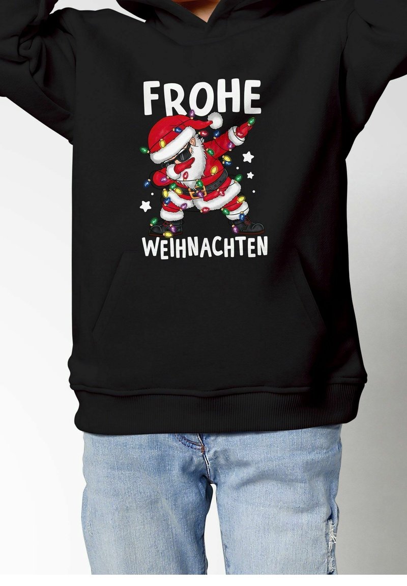 Père Noël dans une pose de dab, enveloppé de guirlandes lumineuses colorées, avec le texte « Frohe Weihnachten » sur un sweat à capuche noir.