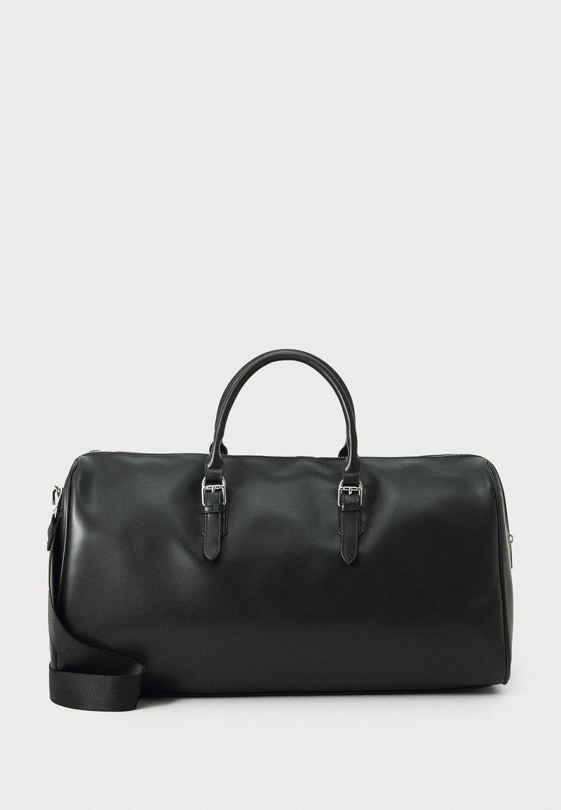 Bolsa de viaje de cuero negro con dobles asas, herrajes plateados y una correa de hombro ajustable. Textura suave con cierre de cremallera.