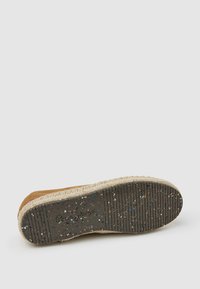 Zapato de ante marrón con una entresuela gruesa de yute texturizado y una suela de goma moteada que presenta patrones de banda lineal y detalles de la marca.