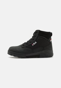 Chaussures montantes noires en combinaison de daim et de mesh, avec une forme à bout rond, une semelle en caoutchouc épaisse et des accents du logo Fila en rouge et blanc.