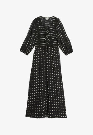 Black polka dot dress with a smocked bodice, three-quarter sleeves, and a tie detail at the neckline. Lightweight, flowing fabric.