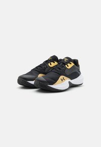 Black athletic shoes with yellow accents, featuring a textured upper, sleek design, white midsole, and rubber outsole with a traction pattern.