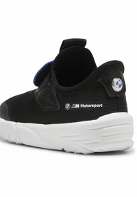 Melnas sporta kurpes ar teksturētu auduma virsmu, zilām akcentiem un baltu gumijas zoli. Malā ir BMW Motorsport zīmols.