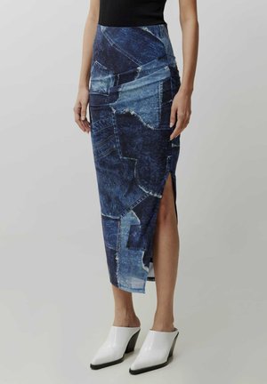 Denim wikkelrok met een patchworkontwerp in verschillende blauwtinten, met een hoge split aan één kant. Gepaard met witte hoge muilen.