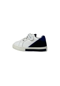 Sneaker bianca con accenti neri e blu, dotata di una fascia in velcro e chiusura a lacci, suola in gomma testurizzata e parte superiore in materiale sintetico liscio.