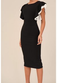 Svart figurnära klänning med vita volangärmar, knälång, slät textur, rundad halsringning och synliga söm detaljer.