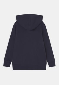 Sudadera con capucha en azul marino, hecha de algodón suave. Presenta mangas largas, un bolsillo canguro y puños y dobladillo acanalados. Diseño sencillo.
