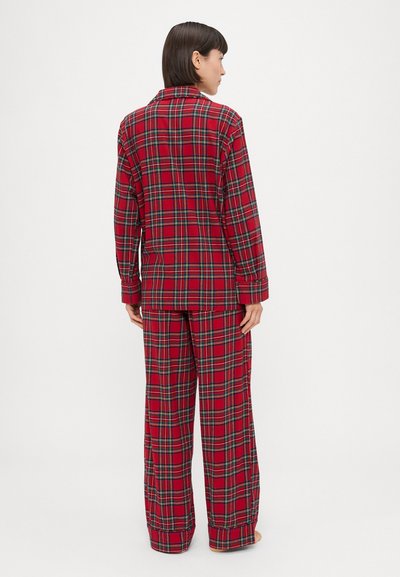 Roter karierten Pyjama-Set bestehend aus einem langärmligen Button-Up-Oberteil und lockeren Hosen mit grünen und schwarzen Akzenten, aus weichem Stoff gefertigt.