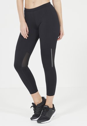 Des leggings noirs avec une taille haute, des panneaux en mesh et une coupe slim, avec des détails supplémentaires autour de la zone du genou et des accents réfléchissants.