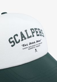 Gorra verde y blanca con el logo "SCALPERS", con texto bordado y una gráfica de calavera en la parte frontal. Hecha de tela, diseño estructurado.