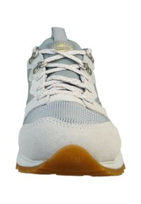 Hellgraue Sportschuhe mit einem Obermaterial aus Mesh und Wildleder, kontrastierenden Schnürsenkeln, Gummisohle und eingeprägtem "est. 1981"-Detail.