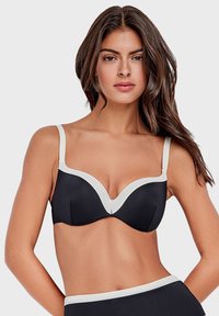 Reggiseno nero con taglio a V, caratterizzato da bordi e spalline bianchi. Texture liscia, supporto con ferretto e design elegante.