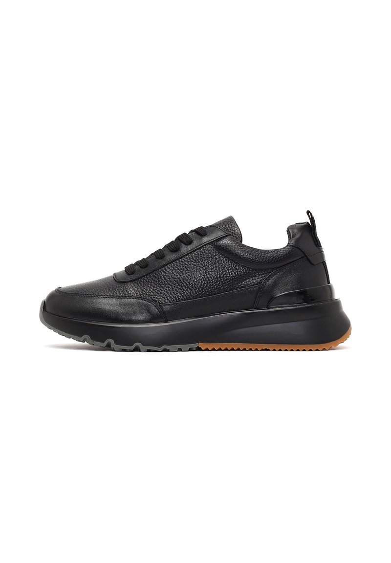 Zwarte leren sneaker met gestructureerde panelen, zes veterogen, een gevoerde kraag en een rubberen zool met een contrasterende gumrand.