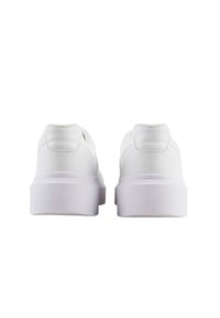 Zapatillas blancas con un acabado suave similar al cuero, puntera redondeada, diseño de perfil bajo y suela gruesa de goma blanca. Sin patrones visibles.