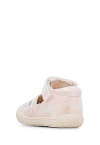 Ljust rosa mockaskor med bakrem, öppen tå och utskärningsdesign. Har en texturerad sula för grepp och en rundad klack för stabilitet.